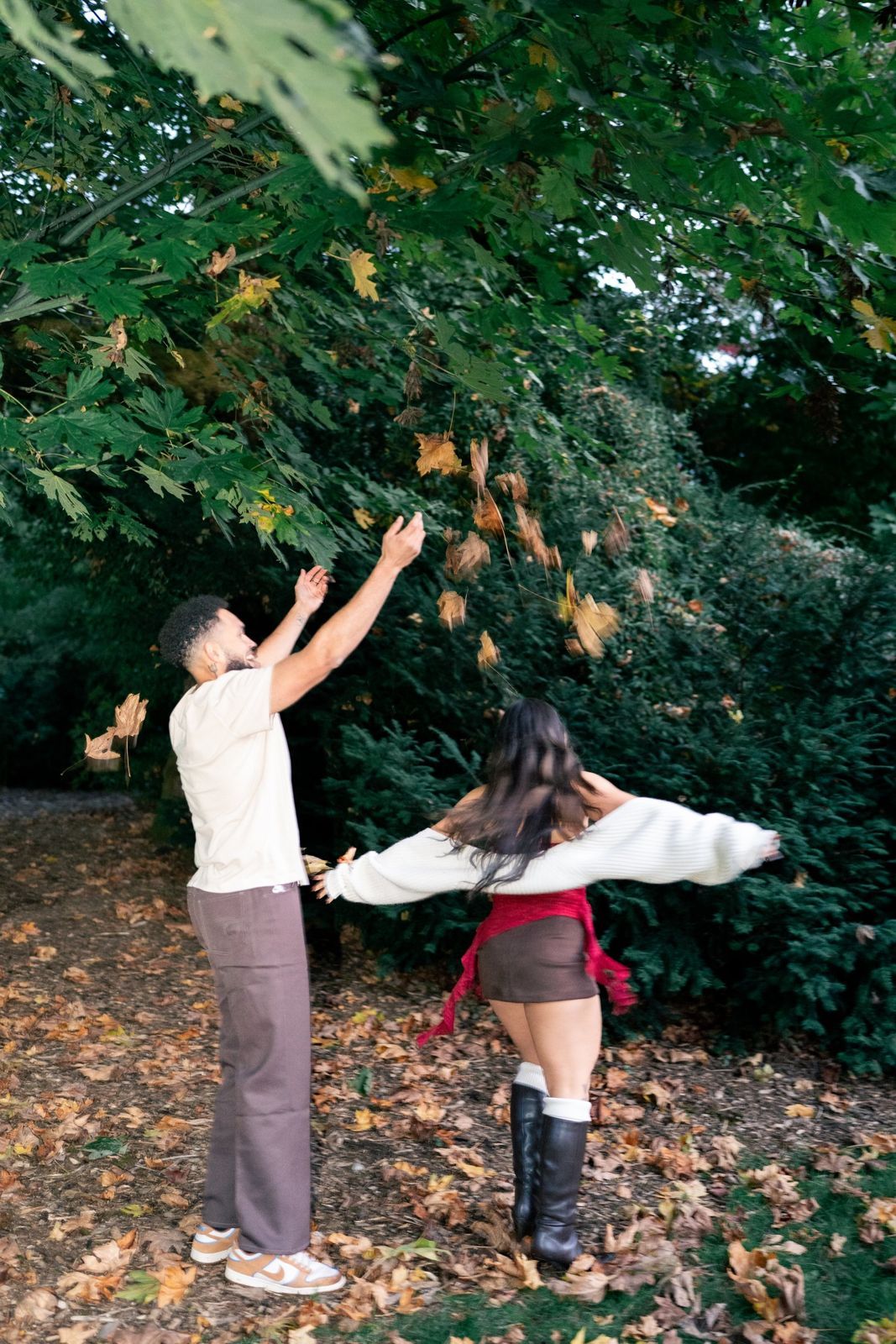 Couple throwing autumn leaves