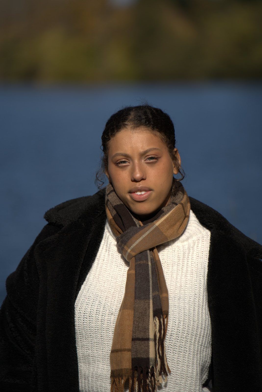 Portrait by the lake in a plaid scarf