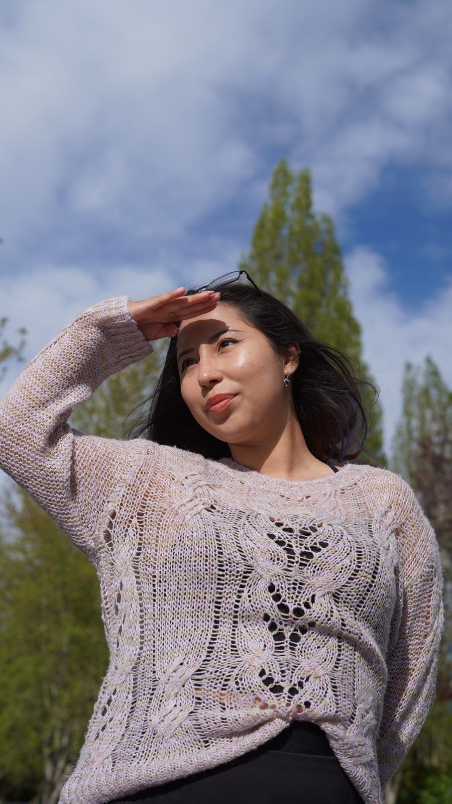 Portrait shading her eyes against a blue sky